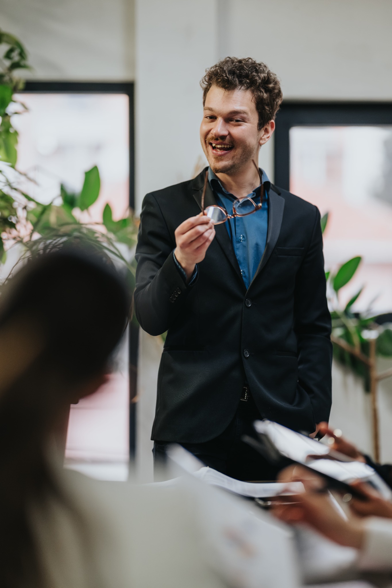 A presenter smiling while speaking to colleagues